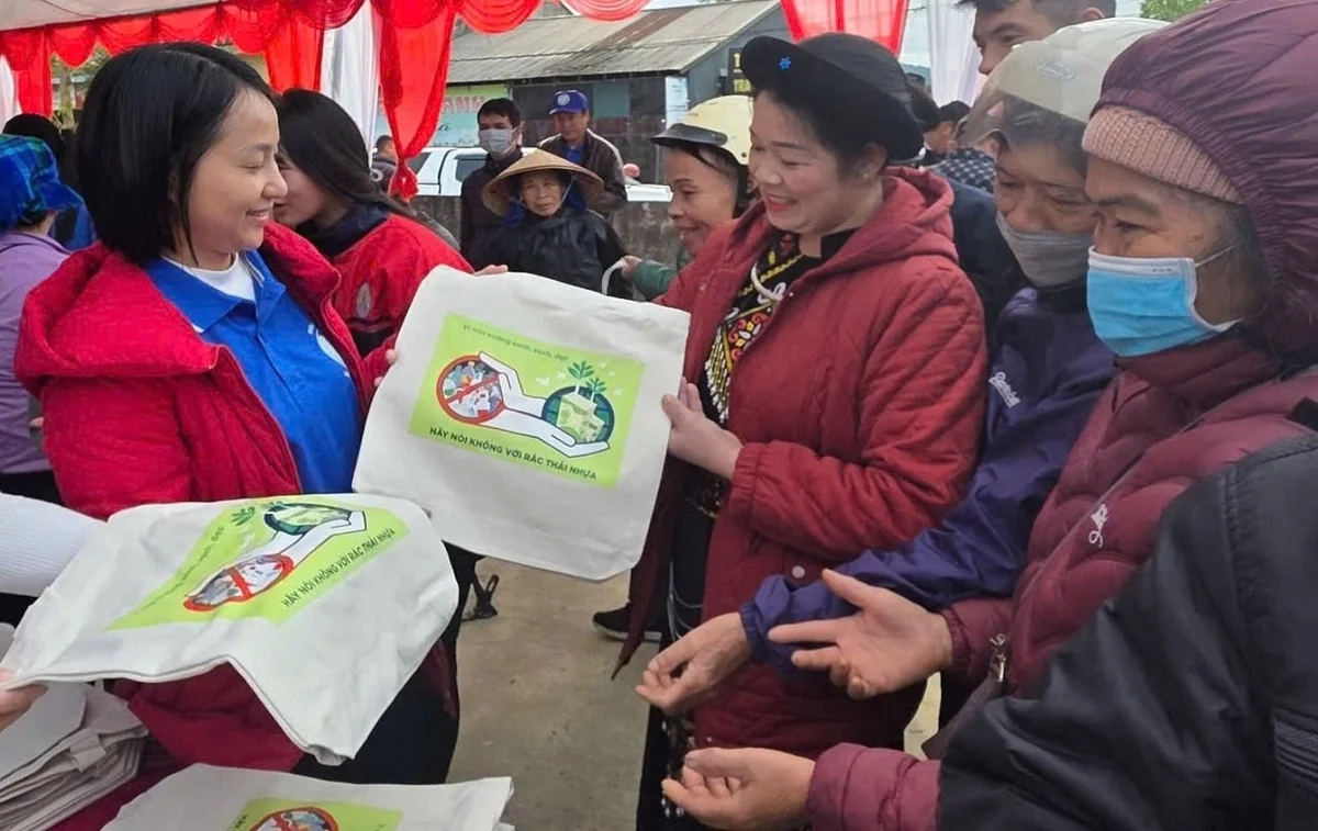 Người dân xã Tân Đoàn hào hứng nhận túi vải thay thế túi nilon trong ngày phát động mô hình chợ phiên không rác nhựa. Ảnh: Hoàng Nghĩa.